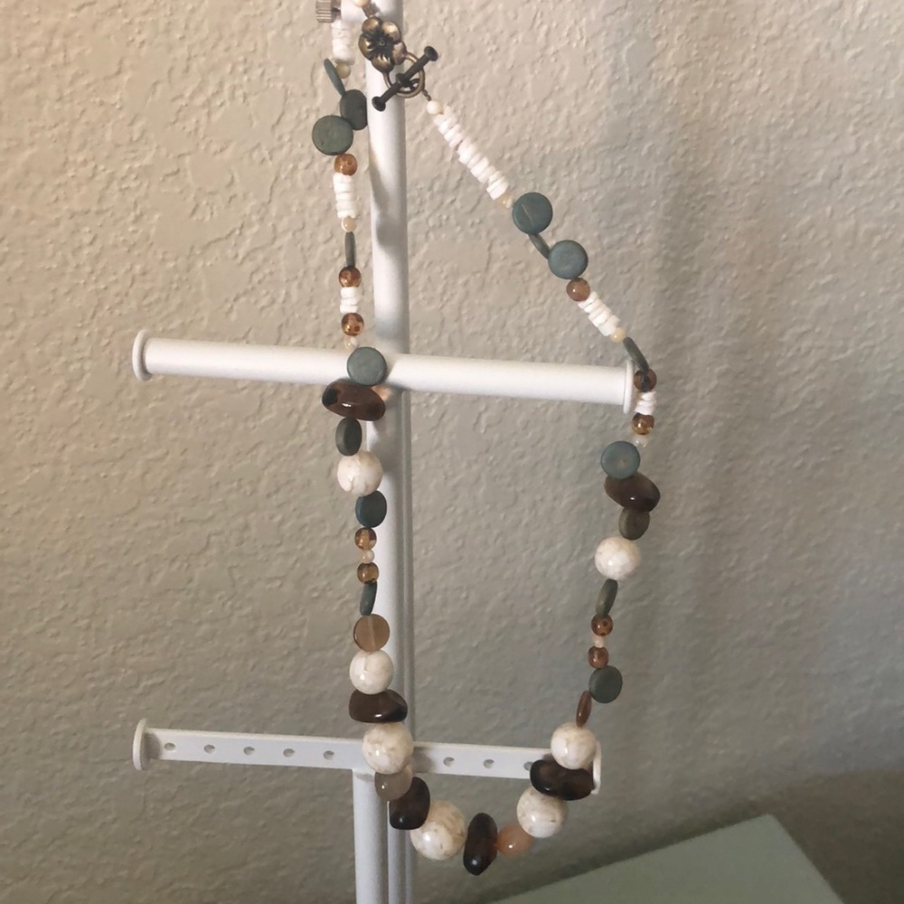 White, brown, and teal necklace with flower clasp